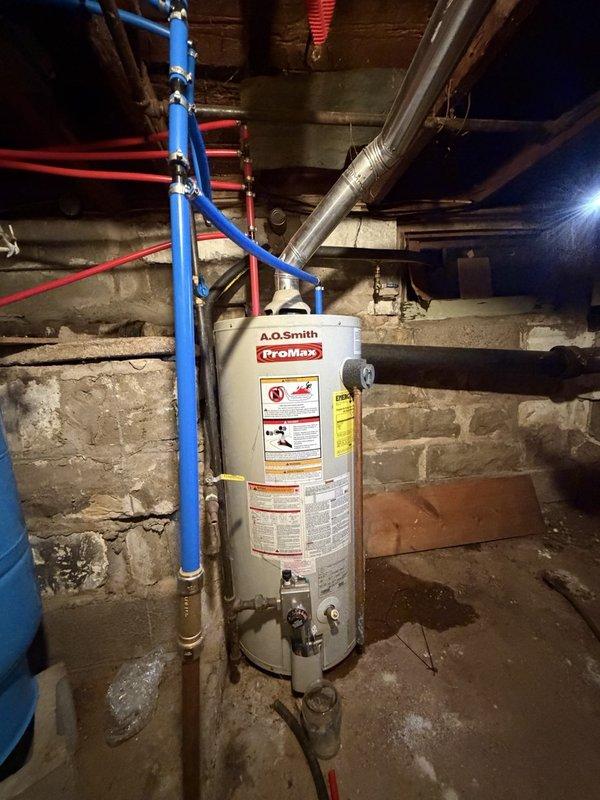 Responded to service call for leaking water heater. Upon inspection, confirmed active leak from existing tank-style water heater requiring immediate replacement. Removed and disposed of failed unit, then installed new A.O. Smith ProMax tank water heater in basement utility area. Connected all supply and discharge lines including PEX and copper piping, installed appropriate shut-off valves, and verified proper temperature and pressure relief valve operation. System tested and confirmed operational with no leaks detected.
