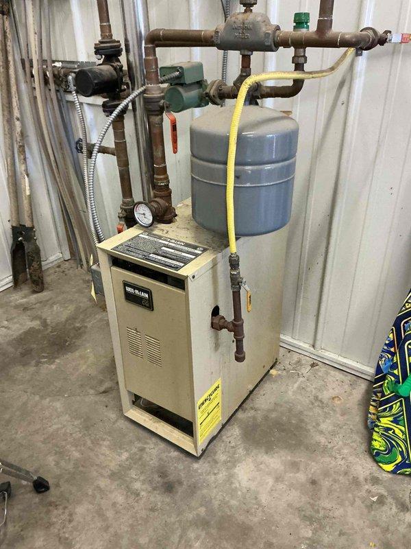 Responded to no heat call on 28-year-old residential hydronic floor heating system with boiler located in shop. Upon inspection, discovered boiler was inoperative due to broken Molex connector that had detached from control board solder points, preventing circulator pumps from receiving power and operating. Additional Molex connector showed signs of wear. System was also found to be completely low on water and was refilled to proper operating pressure. Due to history of repeated water loss and previous service calls requiring water additions, suspected leak in floor loop system. 

Replaced failed control board to restore circulator pump operation and system functionality. Installed shut-off valves on supply side of floor heating loops to enable future isolation testing for leak identification. System was not run extensively during initial diagnosis due to non-functioning circulators to prevent potential damage. Documented equipment condition with photos. Advised that monitoring system 