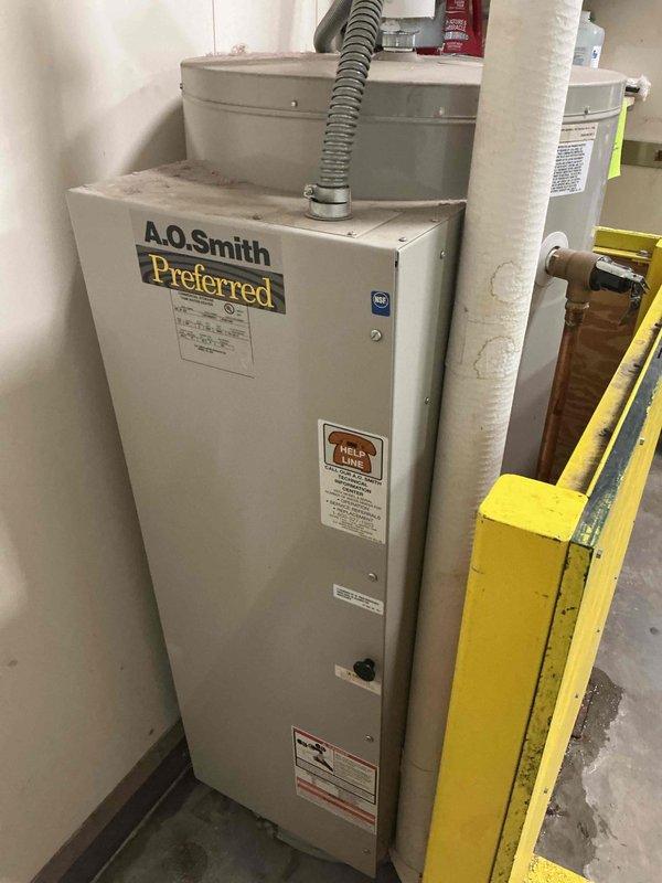 Responded to commercial water heater emergency at PetSmart location where unit had ruptured with active leak from bottom of tank. Upon arrival, immediately isolated water supply, shut down electrical power at panel, and secured the failed A.O. Smith Preferred model water heater to prevent further water damage to facility. Documented existing electrical connections and equipment condition with before photos for replacement planning and insurance purposes.