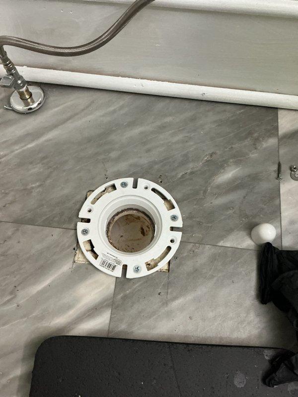 Responded to active water leak originating from toilet in living room area. Upon inspection, discovered existing toilet flange was improperly installed and failed, causing water intrusion into living space. Removed toilet and assessed damaged flange assembly. Removed defective flange hardware and prepared subfloor for proper installation. Installed new code-compliant toilet flange with appropriate mounting hardware and wax ring seal. Secured flange to floor structure per manufacturer specifications and plumbing code requirements. Reinstalled toilet and reconnected water supply line. Tested system for proper operation and verified leak resolution.