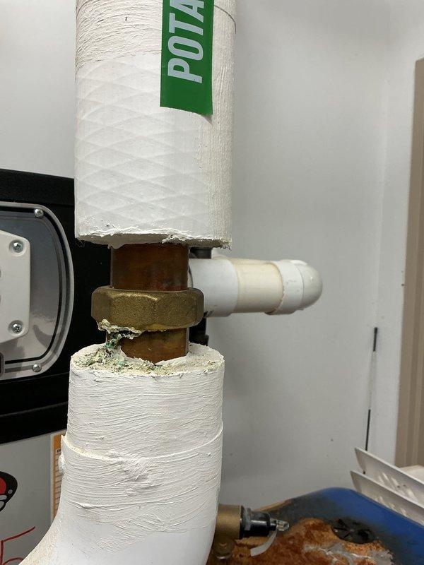 Responded to commercial water heater leak complaint and performed inspection of two water heaters. Upon arrival, identified active drip leaks at copper intake water pipes on both units, with visible corrosion, mineral deposits, and turquoise-blue oxidation patterns indicating ongoing water seepage. Documented conditions with photographs showing corroded brass fittings, deteriorated pipe connections, and water damage staining on equipment panels. Coordinated with maintenance management and submitted findings for repair estimate preparation.