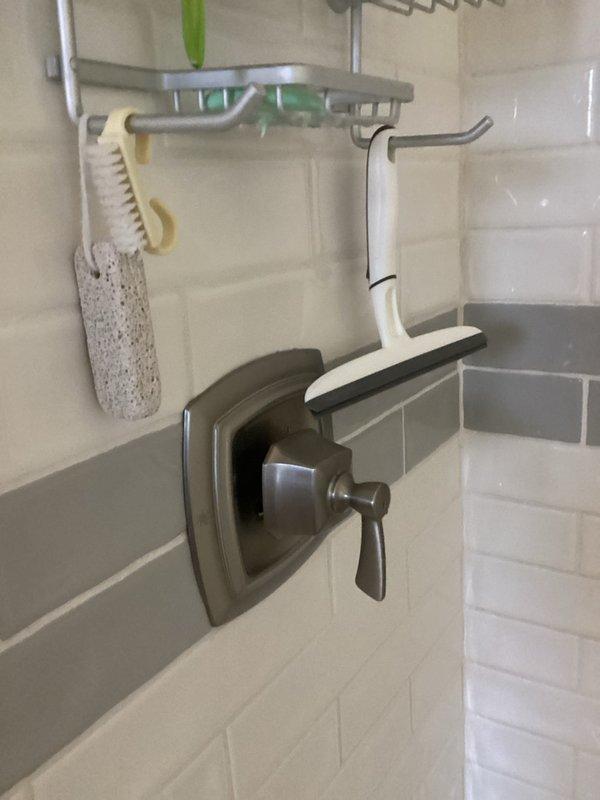 Completed comprehensive plumbing inspection on 1921-built residence as part of recurring maintenance service. Inspected shower valve assembly with brushed nickel trim and shut-off valve installation with flexible braided supply lines in recessed wall box. Documented current conditions and recommended water heater replacement due to age of existing unit.