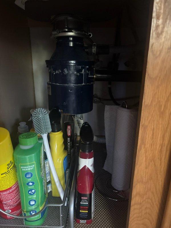Responded to service call for non-functioning garbage disposal with drainage issues. Upon inspection, determined the existing disposal unit was frozen and completely plugged, preventing proper operation and water flow through the sink drain. Removed the failed disposal unit from the mounting assembly beneath the double-basin kitchen sink and disconnected all plumbing connections. Installed new garbage disposal unit, reconnected to existing drain lines and electrical supply, and tested operation to ensure proper functionality and drainage. System restored to full working order.