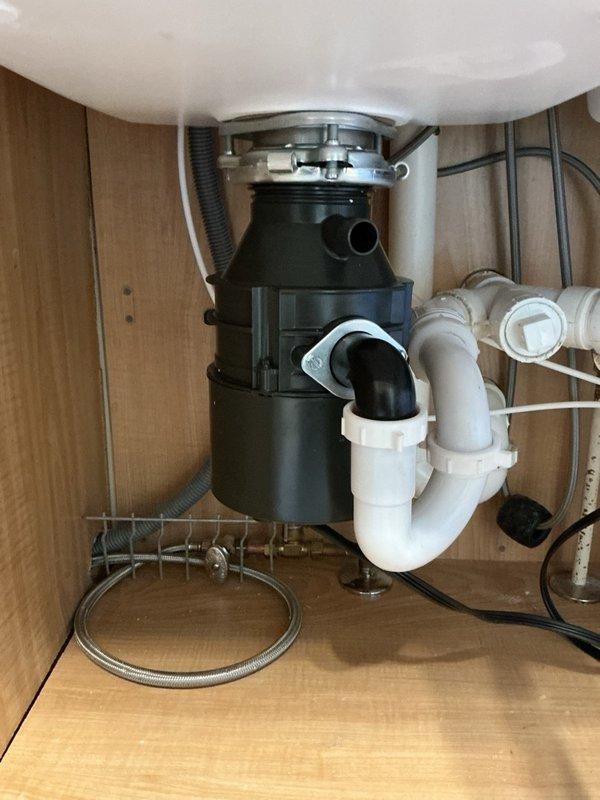 Responded to service call for leaking garbage disposal unit. Upon inspection, determined the disposal had reached end of life and was actively leaking from the bottom housing, creating potential water damage risk to cabinet interior. Removed failed disposal unit, disconnected electrical connection and drain lines, and installed new replacement garbage disposal with proper mounting assembly, PVC drain connections, and electrical hookup to restore full functionality.