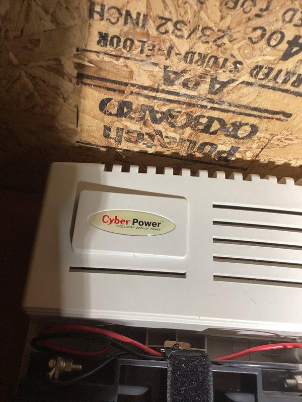 Responded to alarm activation reported as sump pump issue. Upon inspection, determined alarm was originating from a CyberPower battery backup unit installed in crawl space, which provides power to the property's security camera system rather than the sump pump. Unit contains dual B.B. Battery BP20-12 sealed lead-acid batteries with proper wiring connections intact. No plumbing or sump pump issues identified. Advised property owner to contact their telecommunications or security camera service provider for alarm diagnostics and resolution of the backup power system alert.
