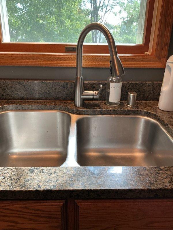 Responded to a clogged kitchen sink drain that was backing up due to heavy accumulation of grease and food debris, including egg shells. Successfully cleared the blockage using a small rigid drain snake machine, restoring proper drainage to the double-basin stainless steel sink. Cleaned work area and removed debris upon completion.