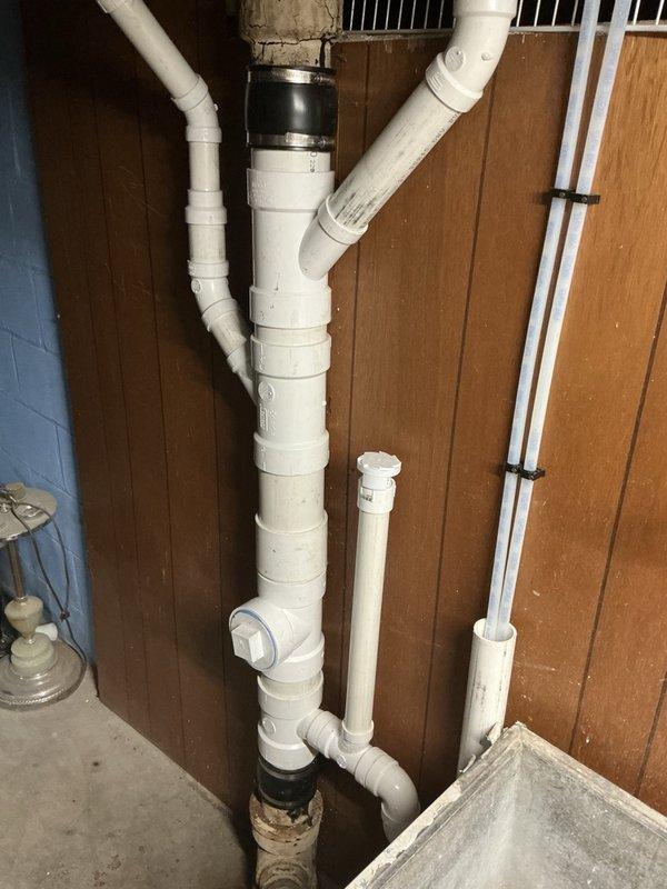 Completed annual family rewards plumbing inspection of water heater and water softener system. Inspected dual Hague water softener tanks with digital control heads, verified proper operation of control valves and shut-off points, and checked salt levels in softener units. Examined PVC drainage system installation including main vertical drain pipe with rubber coupling connectors and associated branch lines. All plumbing components found to be functioning properly with no immediate service needs identified.