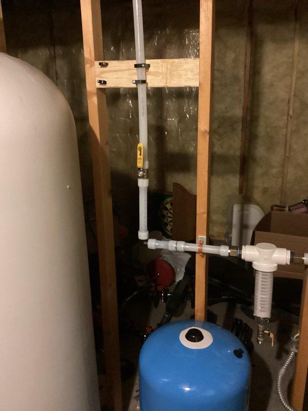 Responded to water quality issues including murky water and film buildup in plumbing fixtures and toilet tanks. Removed malfunctioning acid neutralizer unit that was found in bypass mode, reconnected main water line directly, and thoroughly flushed all supply lines at basement bathroom sink to clear system of sediment and residual contamination.