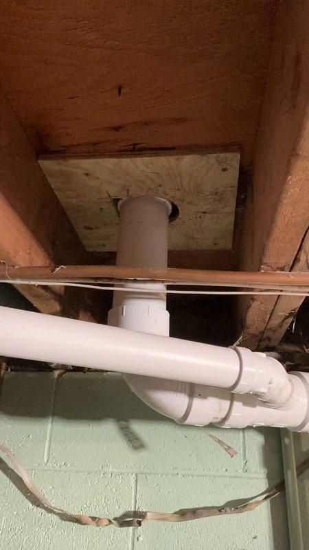 Removed deteriorated cast iron drain piping from 24 inches above floor level to the toilet riser and tied into the existing vertical stack. Replaced the bathtub drain line with new PVC piping, installed a new closet flange, and reset the toilet to proper working condition. All work included floor protection measures and replacement of the vertical drain stack to ensure proper drainage function.