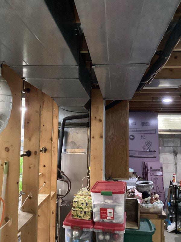 Responded to service call for poor airflow throughout residence, with significant airflow deficiencies reported upstairs and inconsistent distribution between rooms. Performed comprehensive inspection of existing ductwork system, including flexible HVAC ducts, rigid galvanized metal supply lines, and support infrastructure in basement and attic spaces. Documented current ductwork configuration, noting flexible duct routing, copper refrigerant line placement, and overall system layout to assess airflow restriction points and identify opportunities for improved air distribution and system performance.