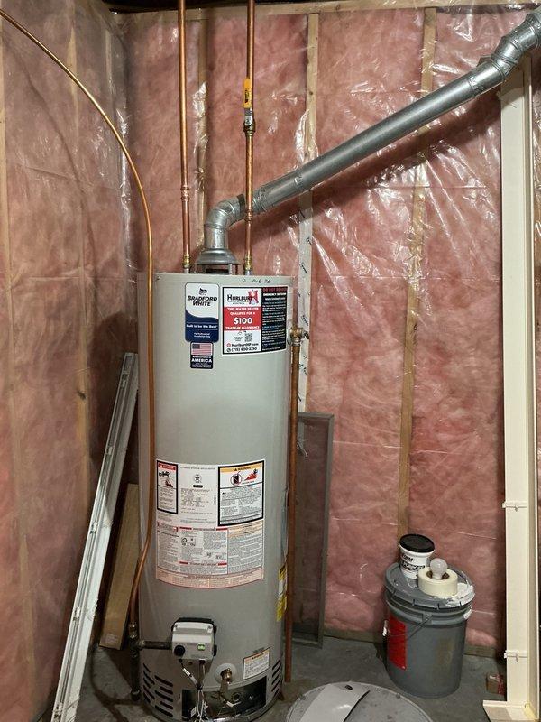 Responded to no hot water complaint at residential property. Upon arrival, inspected existing 40-gallon natural gas water heater and successfully relit pilot light. However, property owner requested full replacement due to age and condition of unit. Removed old water heater and installed new 40-gallon natural gas chimney vent water heater in unfinished basement utility area. Connected copper supply lines to top of unit and installed proper venting with metallic ductwork routed through chimney chase. Installed drain pan beneath unit for leak protection. Connected gas supply line and verified all connections for proper operation and safety. Tested unit operation, confirmed burner ignition, and verified adequate water heating. Inspected chimney draft to ensure proper exhaust ventilation before completing installation. Unit left in full operational condition with hot water restored to property.