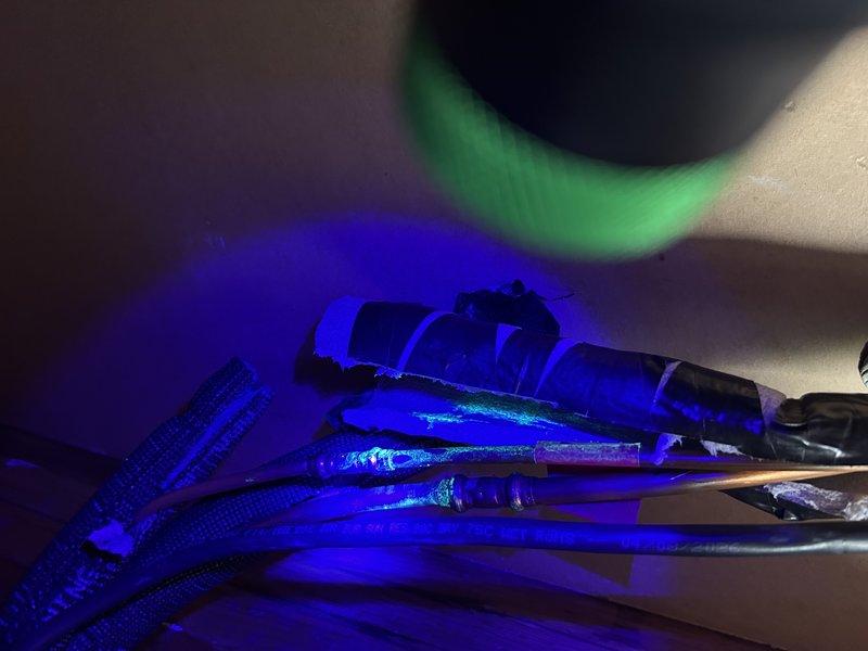 Performed leak search on Mitsubishi Electric mini-split system using UV detection method. Located refrigerant leak at bedroom indoor head unit connections on both high and low side fittings. Replaced defective fittings, evacuated system with vacuum pump, performed nitrogen pressure test to verify integrity, and recharged system to manufacturer specifications. Confirmed all components functioning properly and inspected remaining connections throughout system with no additional leaks detected.