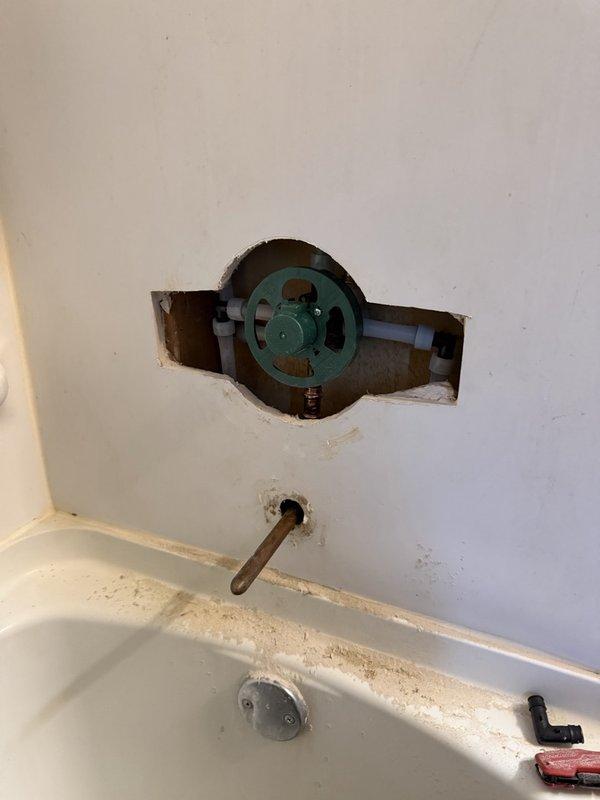 Removed existing shower valve assembly and installed new Moen tub/shower valve with remodel cover plate. Completed installation with better-grade chrome trim kit featuring decorative scalloped trim plate and single-handle control lever. Installed chrome tub spout and standard pop-up drain assembly to complete the fixture upgrade.