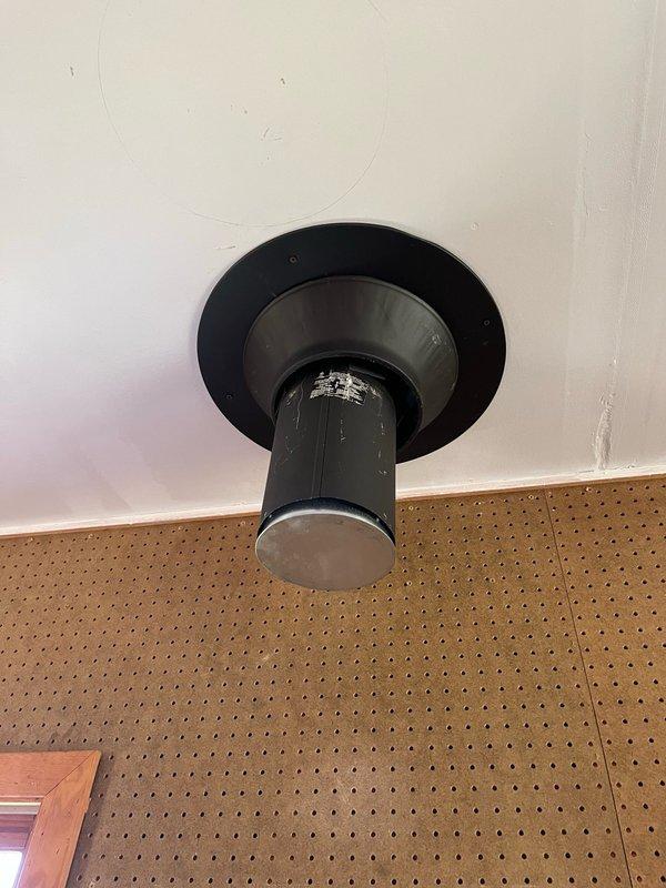 Removed and capped old chimney pipe penetration through ceiling. Installed new 7-inch chimney cap on interior side of chimney opening and properly sealed to prevent air infiltration and weather intrusion. All materials sourced from shop stock.