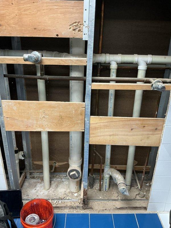 Completed rough-in plumbing work for commercial urinal replacement project. Installed new 2" PVC drain lines, trap arms, and waste piping through wall framing with proper venting and cleanout access points for future maintenance and descaling needs. Roughed in water supply lines to accommodate new flushometer valves, with all plumbing positioned and secured in accordance with code requirements and ready for fixture installation upon delivery of specified urinal units.