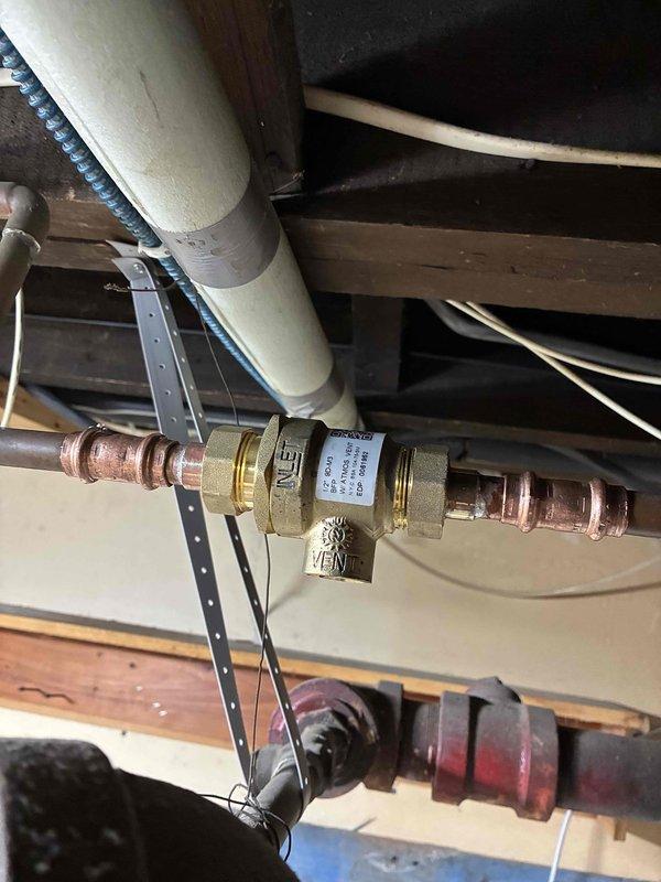 Installed backflow preventer on boiler system that was already equipped with filltrol fitting and autofill tank. Piped in the backflow preventer assembly using copper connections, verified all joints for water-tightness, and adjusted boiler system pressure to proper operating specifications. System is now operational and ready for inspection.