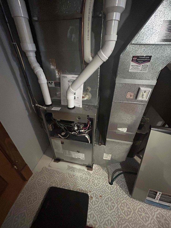 Completed annual furnace tune-up and maintenance inspection on residential heating system. Unit is approximately one year old and operating within normal parameters. Performed comprehensive heating system evaluation including visual inspection of furnace cabinet, burner assembly, heat exchanger, blower motor, and electrical connections. Verified proper operation of all safety controls and limit switches. Inspected condensate drain lines and PVC venting system for proper configuration and drainage. Checked air handler components and ductwork connections. All colored wiring and control board connections found secure with no signs of overheating or damage. System tested under operational conditions with no issues identified. Unit left in proper working order with all access panels secured.