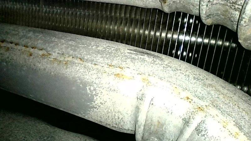 Completed routine maintenance on a 2013 Ruud single-stage gas forced air furnace. Unit is operating within normal parameters; however, the inducer motor exhibits abnormal electrical buzzing noise indicating potential bearing failure, winding vibration, loose mounting hardware, or voltage irregularities requiring further evaluation. Attempted to verify gas manifold pressure but service ports were seized and inaccessible. Inspection revealed exhaust and intake venting constructed of cellular core PVC, which does not meet current code requirements for furnace venting applications. Discussed venting concerns with homeowner and identified markings on piping to confirm material type. Provided quote for replacement of non-compliant cellular core venting with proper schedule 40 PVC. Documented conditions with photographs of equipment and ductwork showing age-related deterioration.