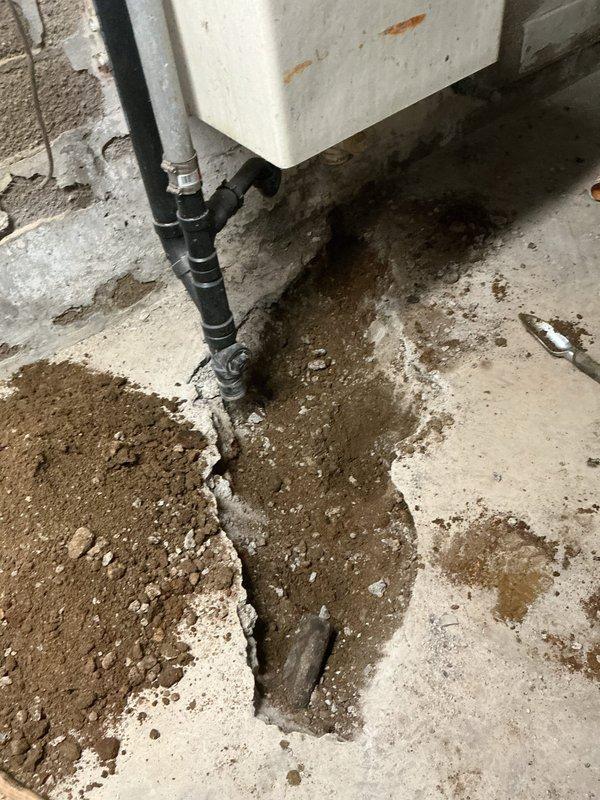 Completed floor drain replacement requiring extensive concrete removal and underground piping renovation. Broke open concrete floor to expose deteriorated cast iron drain piping serving the laundry, kitchen, and floor drain systems. Removed and replaced the first five feet of compromised cast iron piping with new PVC piping, connecting back to existing branch drain lines. Installed new PVC floor drain assembly to code specifications. Properly bedded all new piping with appropriate aggregate material to ensure stable support and prevent future settling. Backfilled excavated area with compacted fill material. Poured and finished new concrete to restore floor surface to original grade. Conducted comprehensive testing of all drain connections to verify proper flow and operation. All systems tested leak-free with adequate drainage performance confirmed prior to completion.