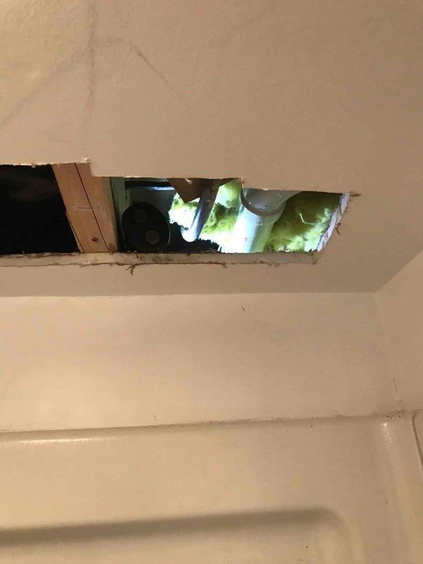 Responded to service call for multiple plumbing issues including inadequate water supply to refrigerator from main line, leak under kitchen sink drain line, and leak at bathroom bathtub. Inspected piping in crawl space/attic area where PVC supply line penetrates through insulation and identified supply line concerns. Accessed ceiling cavity above bathtub to investigate leak source and assess plumbing configuration. Documented conditions with photographs and provided detailed repair estimate to address all identified leaks and water supply deficiencies.