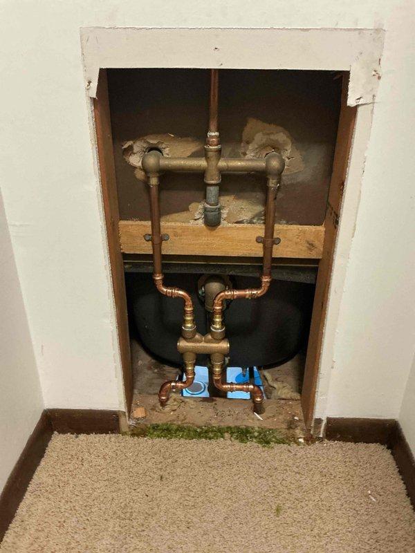 Responded to callback for leak originating from shower area following recent plumbing work. Upon investigation, identified tub spout as source of leak. Created wall access opening to expose copper supply lines and valve assemblies. Repaired leaking tub spout connection through dapping procedure. Tested system by filling bathtub to verify leak resolution and proper water containment.