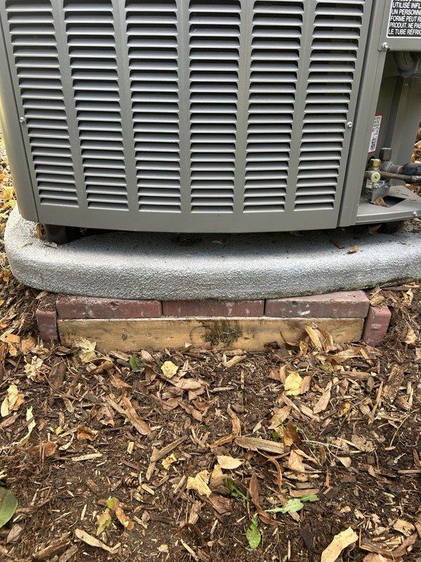 Responded to service call for recently installed outdoor condenser unit experiencing instability due to unstable ground conditions and deteriorated wooden support base. Leveled and prepared ground surface, installed 4x4 plywood base, and positioned 1" landscape pavers to create stable, level foundation for condenser unit. Verified unit was properly leveled and balanced on new paver support system to prevent future settling and ensure optimal equipment operation.