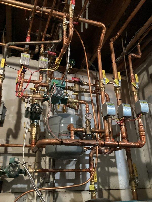 Completed comprehensive heating maintenance visit as part of membership agreement, servicing both boiler system and forced air furnace. Performed complete tune-up procedures on multi-zone hydronic heating system with expansion tank, zone valves, and circulator pumps, inspecting all copper piping, brass ball valves, pressure relief devices, and control components. Inspected forced air system evaporator coil assembly and refrigerant lines, noting minor dust accumulation on coil fins; all equipment operating within normal parameters with no immediate repairs required.