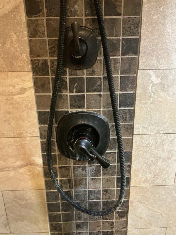 Responded to a dual plumbing issue involving a leaking shower valve and a leaking main water shut-off valve located before the meter. Upon inspection, found the shower valve cartridge was broken and causing water leakage in the downstairs shower. The main shut-off valve was also leaking badly at the handle area, which occurred after the homeowner attempted to replace the shower faucet and cycled the main valve. Tightened the bonnet nut on the main shut-off valve before the meter to stop the leak at that location. Replaced the broken shower cartridge with a new unit, restoring proper function to the shower control system. Both repairs successfully completed, restoring full water service to the residence.