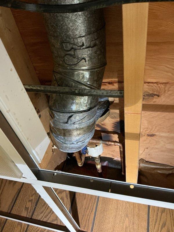 Responded to water leak emergency in kitchen area where active dripping was occurring through drop ceiling onto floor and ductwork below cabinet. Upon investigation, located pinhole leak in copper water supply line beneath kitchen sink. Removed damaged section of copper pipe and replaced with PEX tubing using appropriate fittings and connections. Tested system for proper water flow and verified no additional leaks present. Restored water service to affected area.
