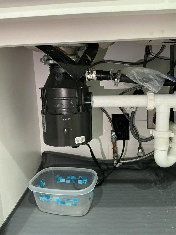 Responded to service call for reported garbage disposal leak. Upon diagnostic inspection, unable to replicate or locate any active leaking from the existing disposal unit. Customer requested full replacement of the garbage disposal regardless of diagnostic findings. 

Removed existing garbage disposal unit from mounting assembly and disconnected all electrical and plumbing connections. Installed new GrindSmart garbage disposal, ensuring proper alignment with sink mounting flange and secure attachment to drain assembly. Connected disposal to existing P-trap configuration using appropriate PVC drainage components. Verified all connections were properly sealed and torqued to manufacturer specifications.

Restored electrical power to unit and conducted operational testing of new garbage disposal. Ran disposal through multiple cycles with water flow to verify proper grinding function and drainage. Performed thorough leak inspection of all connection points including mounting flange, dischar