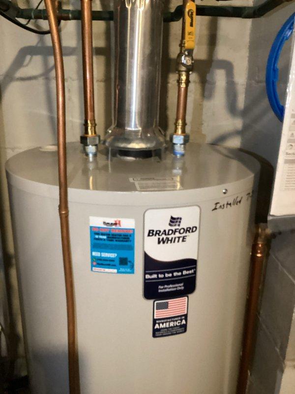Performed scheduled heating maintenance on a 27-year-old Carrier system, including inspection of the heat exchanger with a borescope camera, which revealed heavy rust and a jagged crack-like corrosion pattern with staining and debris along the metal surface. Carbon monoxide readings were taken as a safety precaution, and the adjacent water heater and its flue, connections, and valves were visually checked and found clean with no visible rust or damage.