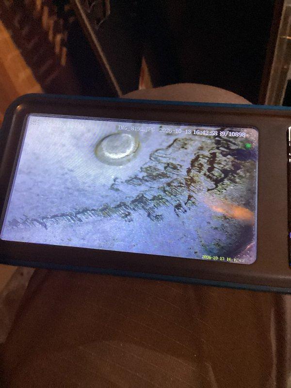 Performed scheduled heating maintenance on a 27-year-old Carrier system, including inspection of the heat exchanger with a borescope camera, which revealed heavy rust and a jagged crack-like corrosion pattern with staining and debris along the metal surface. Carbon monoxide readings were taken as a safety precaution, and the adjacent water heater and its flue, connections, and valves were visually checked and found clean with no visible rust or damage.