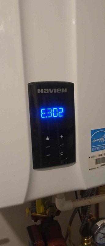 Diagnosed the garbage disposal as non-functional due to a seized motor causing jamming and excessive noise; removed the failed unit and installed a new disposal. Also inspected the Navien tankless water heater, which displayed an E302 error code on the control panel while operating normally, with no visible damage, corrosion, or leaks observed at the unit or its connections.