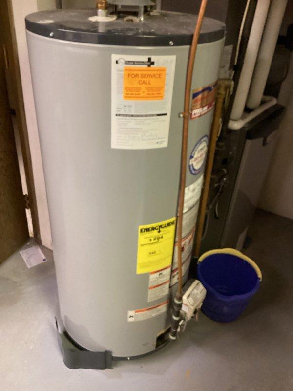 Diagnosed a gas-fired tank-style water heater with no hot water output and a leaking temperature and pressure (T&P) relief valve, confirming the tank had failed and required replacement. Isolated the gas and water supplies, drained the unit, and disconnected the gas line, water connections, and venting. The failed heater was removed and the new unit set in place, then reconnected and tested for proper operation and leaks.