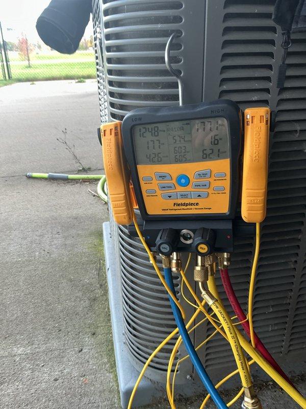 Responded to a no-cool complaint on a 10+ year old Lennox split system with a history of a frozen indoor coil and a previously suspected refrigerant leak at the A-coil. Connected a digital manifold gauge set to the condenser and checked system pressures, which indicated a low refrigerant charge, though current ambient conditions prevented a conclusive charge verification. Recommended either replacing the A-coil or adding refrigerant and performing a leak check, with a recheck of charge on a sunny day around 70°F.