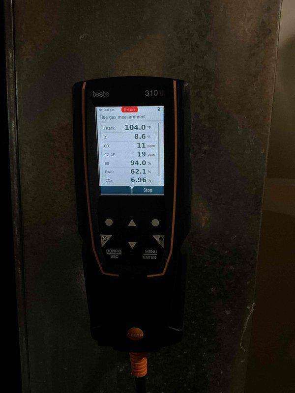 Performed annual maintenance on a 7-year-old Lennox two-stage furnace, including cleaning the flame rod and verifying inducer motor amperage and HSI ohms within specification. Tested first- and second-stage heat operation via the S30 thermostat, confirming proper flame, blower function, and combustion analysis (CO 11 ppm, 94.0% efficiency), with the unit also supplying a Navien high-efficiency boiler for in-floor radiant heat (system pressure 25 psi, boiler heating normally). A small amount of water spilled onto the garage floor during an attempted boiler drain performed without isolating the supply.