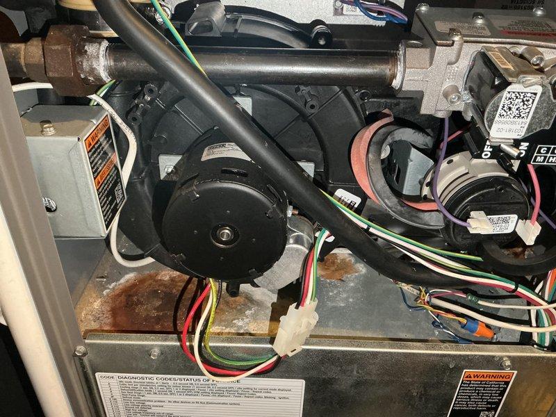 Performed a full tune-up on a 13-year-old gas furnace. Gas pressures verified in low and high fire, flue CO levels safe, and ignitor and flame sensor tested within spec (flame sensor cleaned); blower motor, control board, and remaining components tested within spec. Found the inducer draft motor housing separated and leaking condensation into the upper cabinet, with resulting rust and corrosion. Also identified a seam on the heat exchanger that may be cracked, though a through-crack could not be confirmed; photos documented for comparison at the next tune-up. The furnace is currently operational, with inducer and heat exchanger replacement (or furnace replacement) recommended.