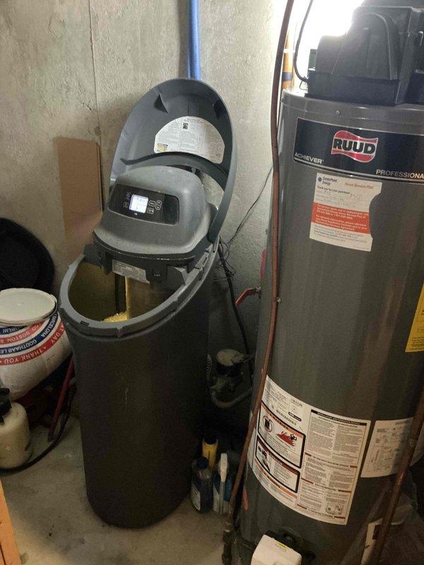 Inspected a Kenmore 520 water softener in a roughly 20-year-old home displaying an Error 1 code, with the brine basin full of water and not draining, and evaluated it as a possible source of the leak flagged by the utility company. Documented the unit's condition, which showed no visible rust or external leakage, and prepared an estimate for water treatment repair or replacement.