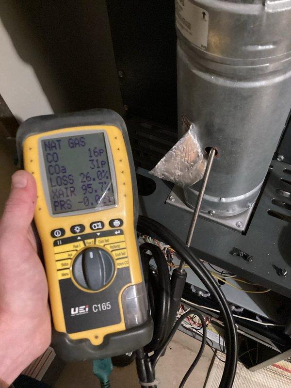 Responded to a no-heat call on a 10+ year old furnace that was locked out with a red fault light and would not respond to a reset. Diagnosed a blocked pressure switch port as the cause of the failure to initiate the heat cycle, cleared the obstruction, and restored normal operation. Performed the requested routine maintenance, including a combustion analysis through the flue (CO 16 ppm, 26.0% stack loss, 95.7% excess air) and an electrical check of the blower circuit with a clamp meter.