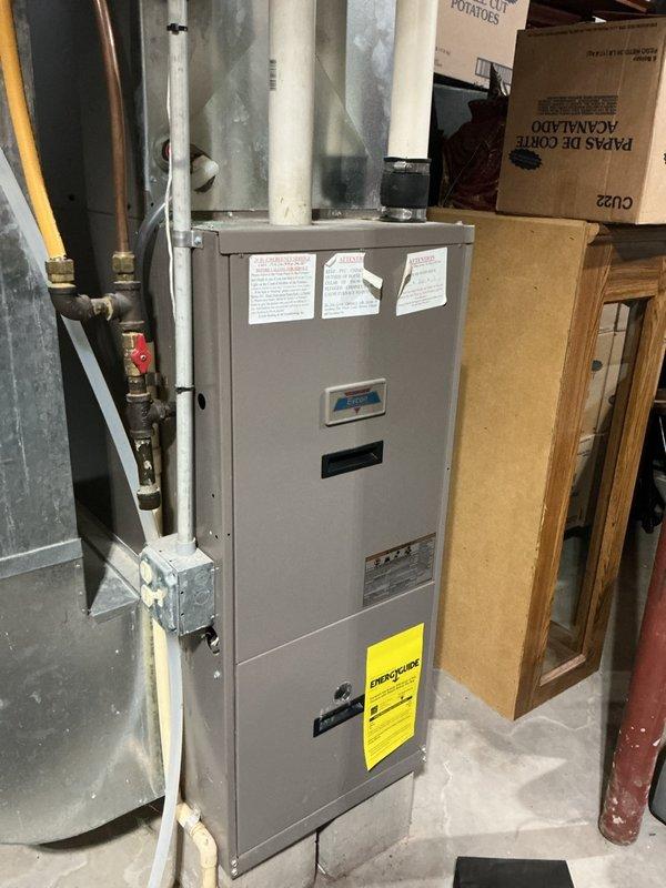 Performed a plumbing inspection of the bathroom toilet and its supply components, confirming the braided flexible supply line and shut-off valve were properly connected with no visible leaks, corrosion, or damage. Also inspected the gas furnace installation, including the gas supply line and shutoff valve, PVC venting, and condensate drain tubing, noting peeling warning labels on the cabinet but no apparent leaks or defects in the plumbing and gas connections.