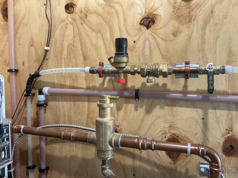 Responded to a reported water softener not consuming salt and inspected the associated mechanical piping. Visually verified the hydronic and plumbing assembly, including the brass fittings, shutoff ball valve, air vent, SUPERVENT air separator, and copper and cross-linked tubing connections, and found all components clean and secure with no leaks, corrosion, or damage. The water treatment equipment was evaluated for salt usage, with no leaks or visible defects observed at the inspected piping.