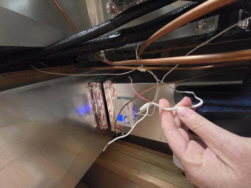 Responded to an install callback and secured the cased coil side panel that had come loose, using a longer screw for a positive hold. Sealed the gap at the vinyl boot overlap on the supply plenum with foil tape to eliminate air leakage. Identified the loose low-voltage wire as the humidifier's outdoor temperature sensor lead and removed it, as the unit is configured to operate without the ODT sensor; all other components were inspected and found in good order.
