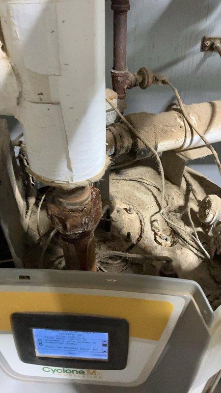 Responded to a no-hot-water call on a tanked gas water heater displaying a flame sensor error and found water present in the combustion chamber, indicating internal tank failure. Observed heavy rust and corrosion on the fittings, deteriorated pipe insulation, and significant dust and debris buildup on the unit. Determined the water heater is beyond repair and requires replacement, and prepared a part order form for a new unit.