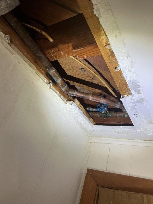 Located a pinhole leak in the copper supply line above the main shutoff that was causing ceiling damage in the basement. Cut an access opening in the ceiling, installed a new ball valve, and repiped the affected section with new copper using press-fit connections to eliminate the failed pipe. System was pressurized and checked to confirm the leak was resolved.