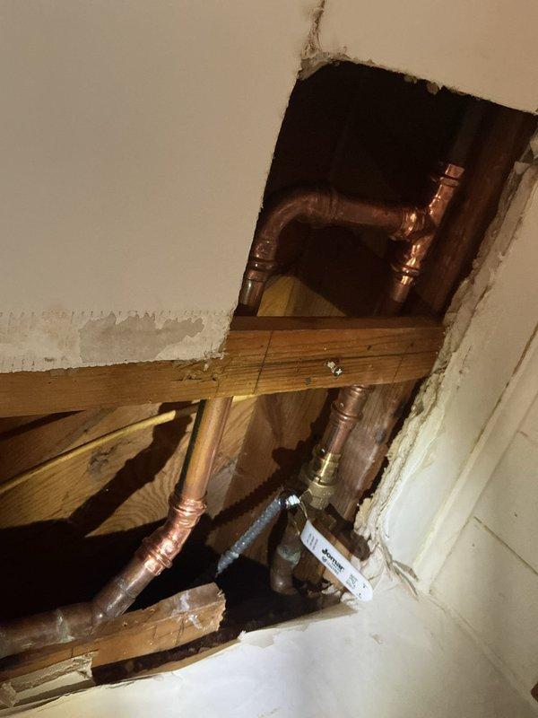 Located a pinhole leak in the copper supply line above the main shutoff that was causing ceiling damage in the basement. Cut an access opening in the ceiling, installed a new ball valve, and repiped the affected section with new copper using press-fit connections to eliminate the failed pipe. System was pressurized and checked to confirm the leak was resolved.