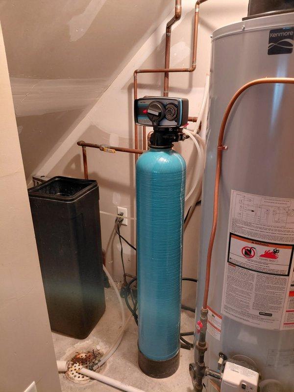 Inspected the metered water softener system, including the control valve head, brine tank, and associated plumbing, in response to reported non-operation. Diagnosed that the softener no longer cycles through all regeneration modes, indicating a malfunction within the control valve and/or its drive components; the unit is not functioning as intended and requires repair to restore proper regeneration operation.