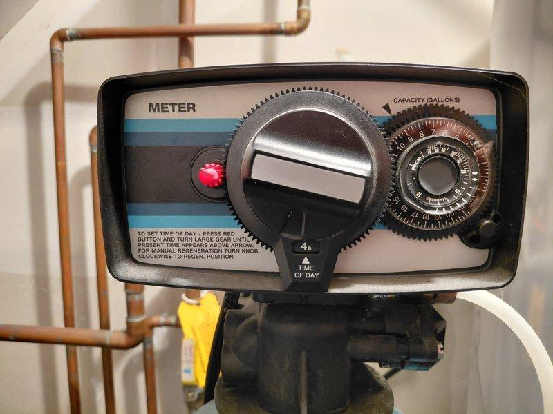 Inspected the metered water softener system, including the control valve head, brine tank, and associated plumbing, in response to reported non-operation. Diagnosed that the softener no longer cycles through all regeneration modes, indicating a malfunction within the control valve and/or its drive components; the unit is not functioning as intended and requires repair to restore proper regeneration operation.