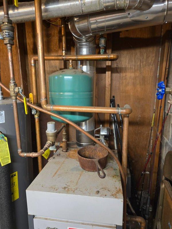 Performed a tune-up and inspection on an older Slant/Fin gas-fired boiler that was underperforming. System pressure was verified at 16 PSI, and a leaking air vent and an expansion tank nearing waterlogged condition were identified, along with surface rust on the unit. Repair and replacement options were presented given the age and condition of the equipment.