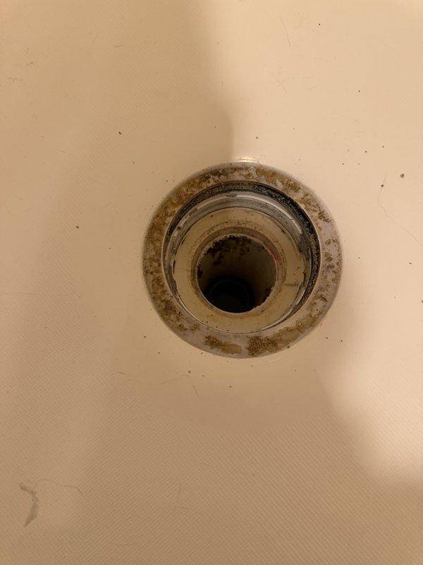 Located the water leak at the master bathroom shower and determined the source to be a failed plumber's putty seal at the shower drain flange. Removed the drain strainer, thoroughly cleaned the flange and surrounding surface of mineral deposits and debris, and resealed the drain with silicone to restore a watertight seal.