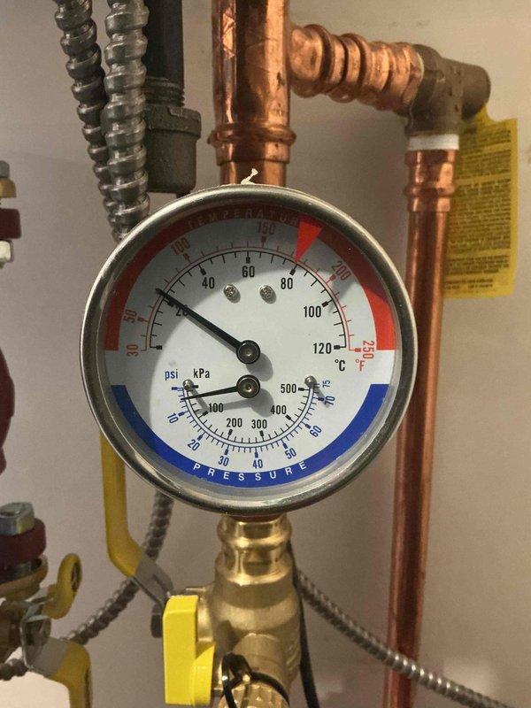 Diagnosed a Navien boiler serving the radiant floor heating system that was faulting on a low water pressure error code. Opened the system fill valve and repressurized the loop to approximately 15 psi, then monitored operation to confirm the boiler fired, held pressure, and heated properly. Instructed the homeowner on how to read the system pressure gauge and manually add water to maintain proper pressure.